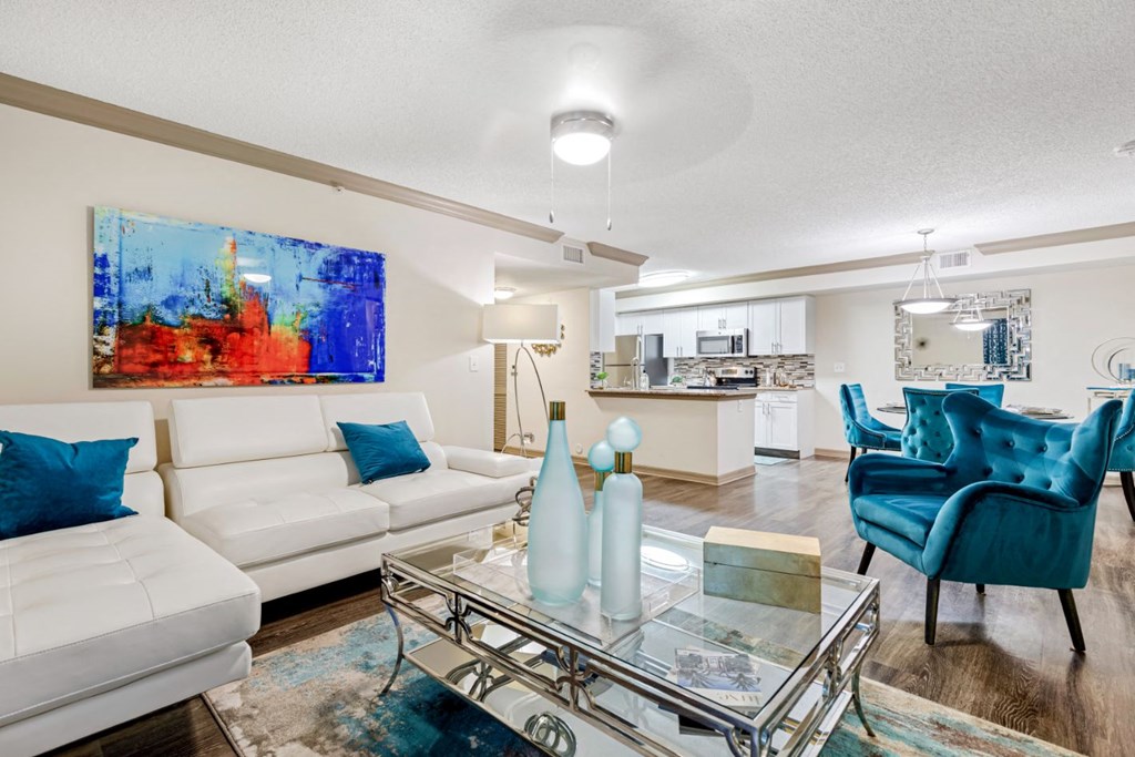 A living room with a white couch and a blue chair.