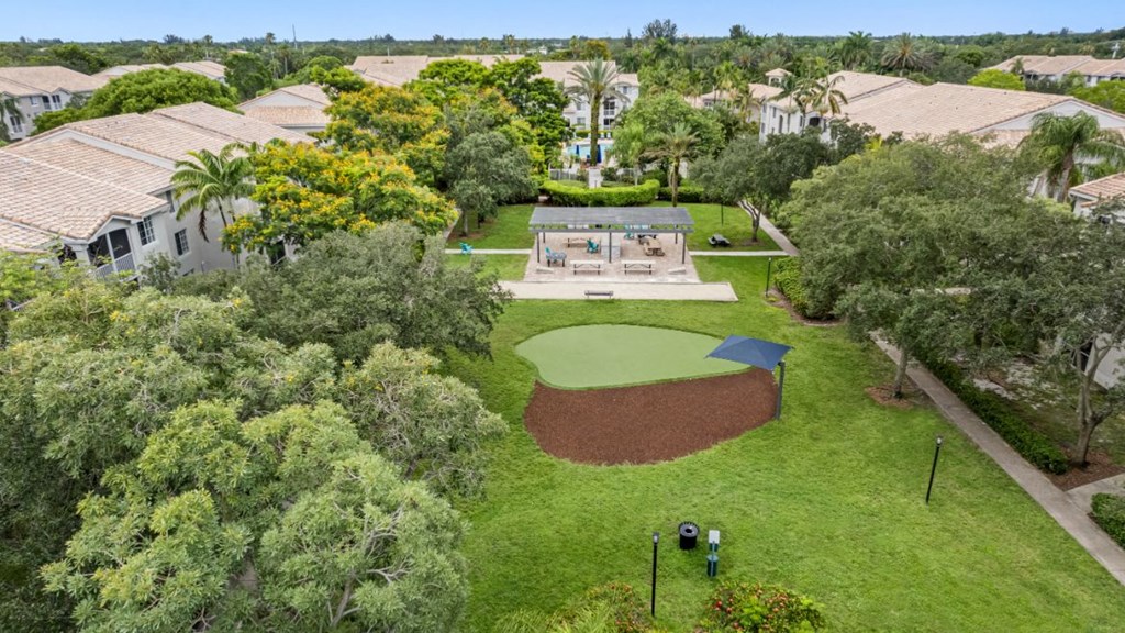 A small baseball field is surrounded by trees and houses.