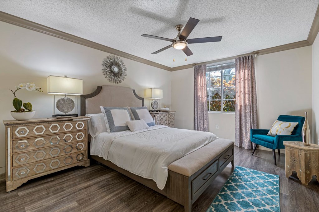 A bedroom with a bed, a chair, and a dresser.