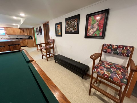 A room with a pool table and a chair.