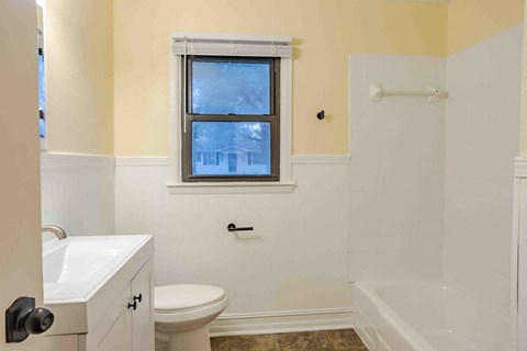 A bathroom with a toilet, sink, and bathtub.