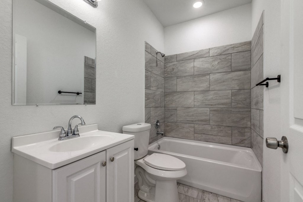 A bathroom with a white sink, toilet, and bathtub.