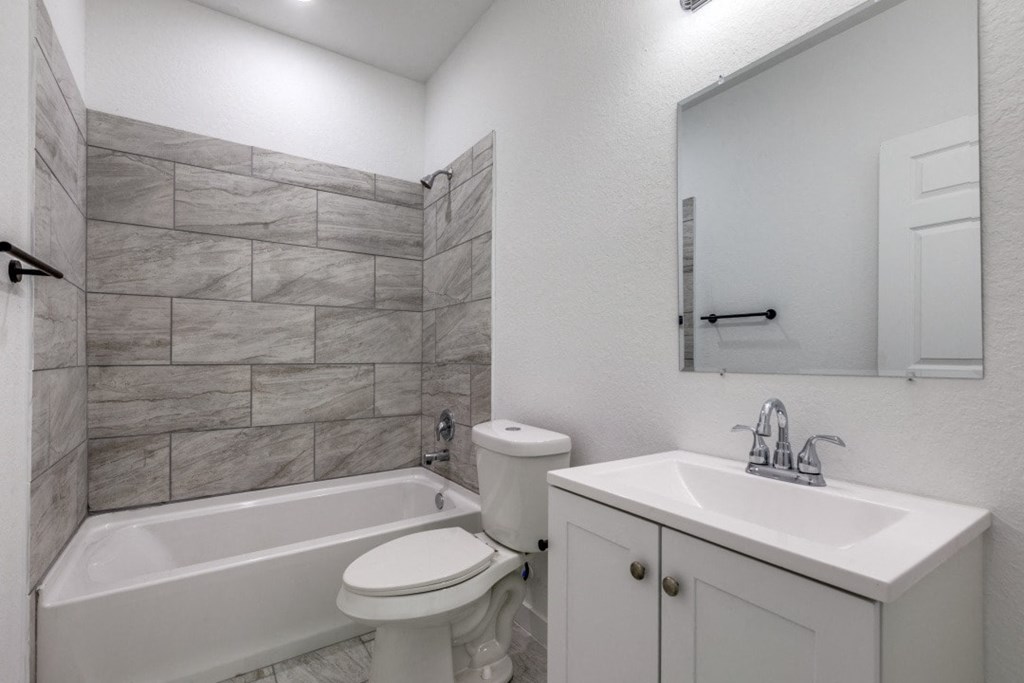 A white bathroom with a toilet, sink, and tub.