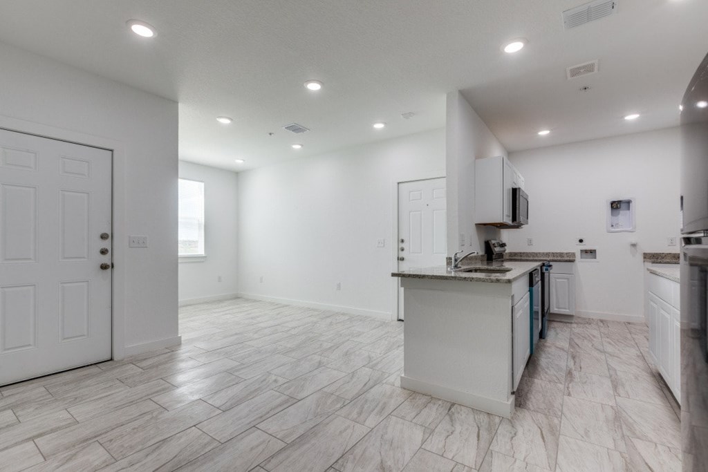 A spacious kitchen with white cabinets and a central island.