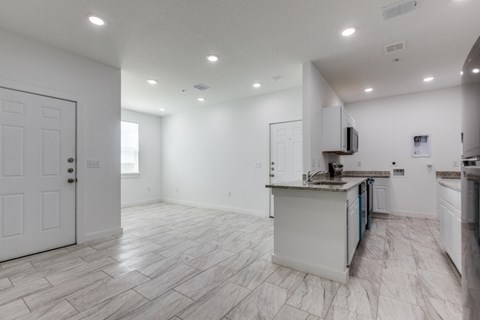 A spacious kitchen with white cabinets and a central island.
