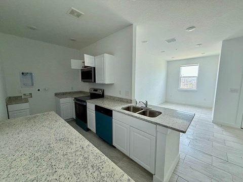 A kitchen with granite countertops and white cabinets.