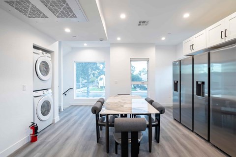 A modern kitchen with a dining table and chairs.