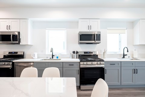 A modern kitchen with white cabinets and appliances.