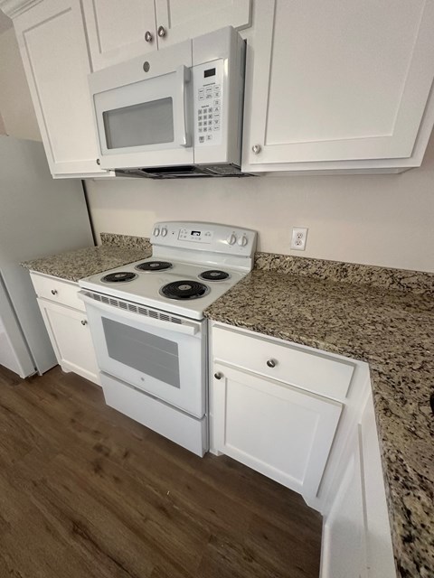 A white kitchen with a microwave and stove.
