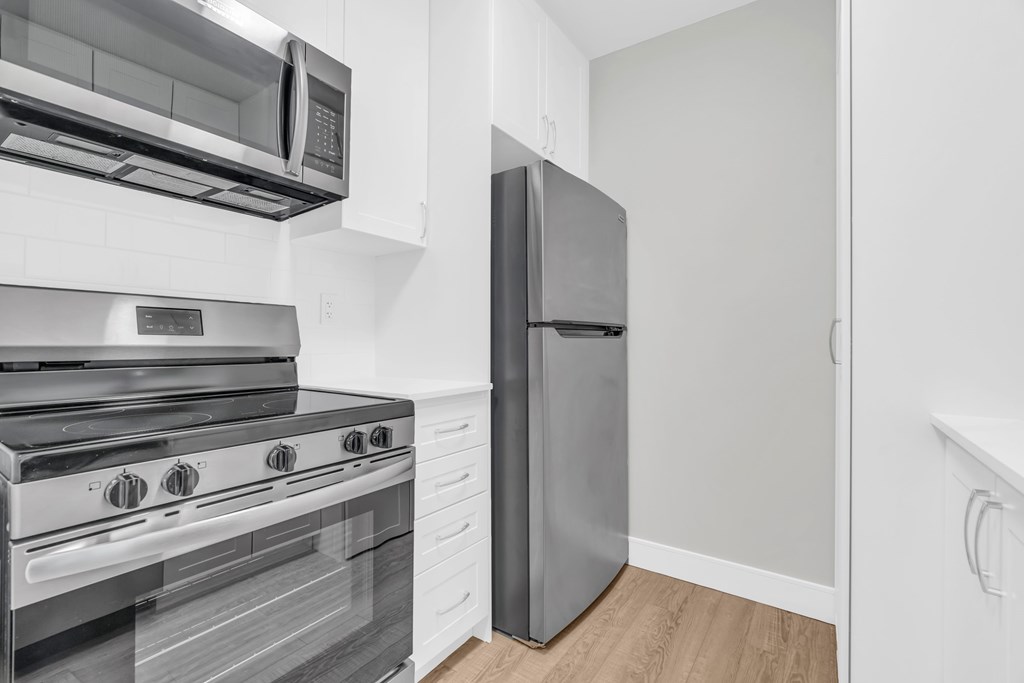 A modern kitchen with a stainless steel oven and microwave.