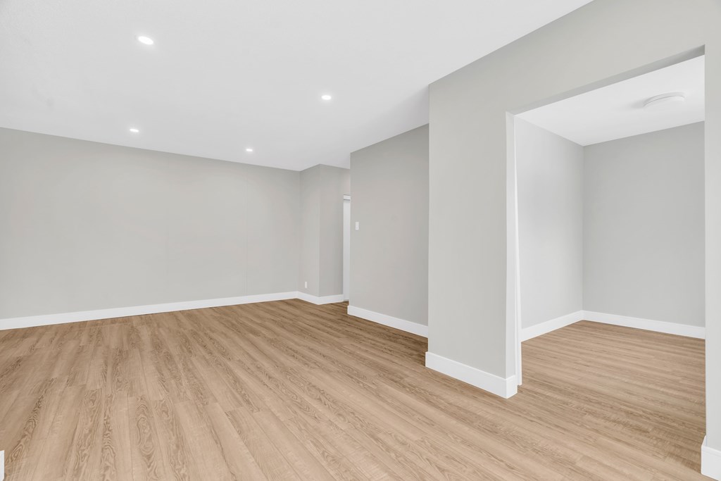 A room with wooden flooring and white walls.