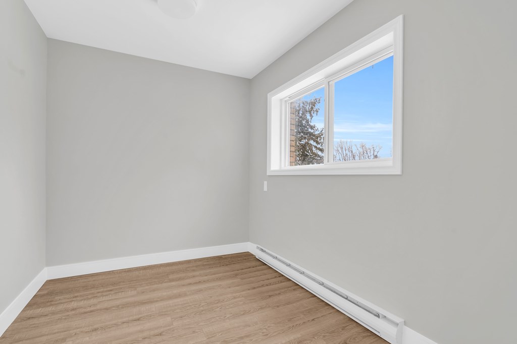 A room with a window and wooden floor.