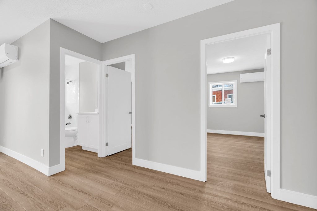 A room with a white door and a white wall with a poster on it.