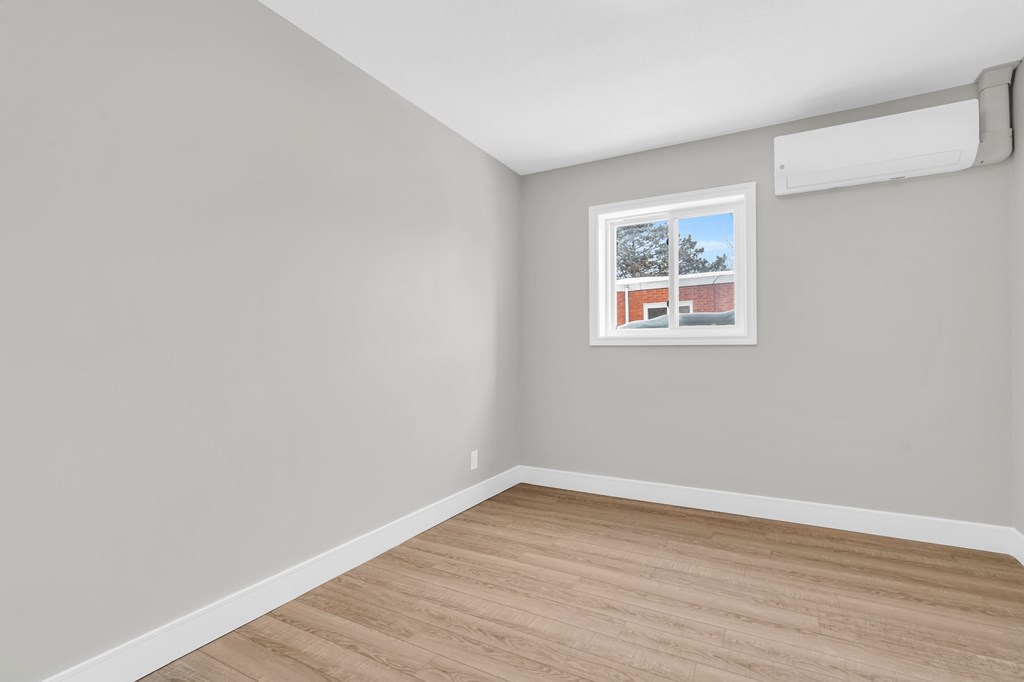 A room with a window and a picture on the wall.