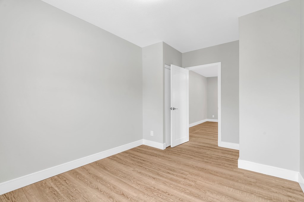 A room with wooden flooring and white walls.