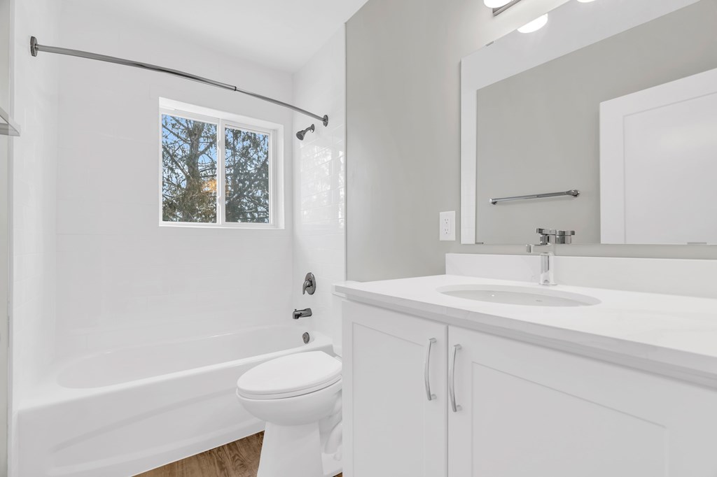 A white bathroom with a toilet, sink, and bathtub.