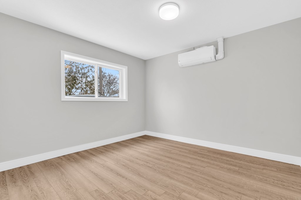 A room with a window and a white ceiling light.
