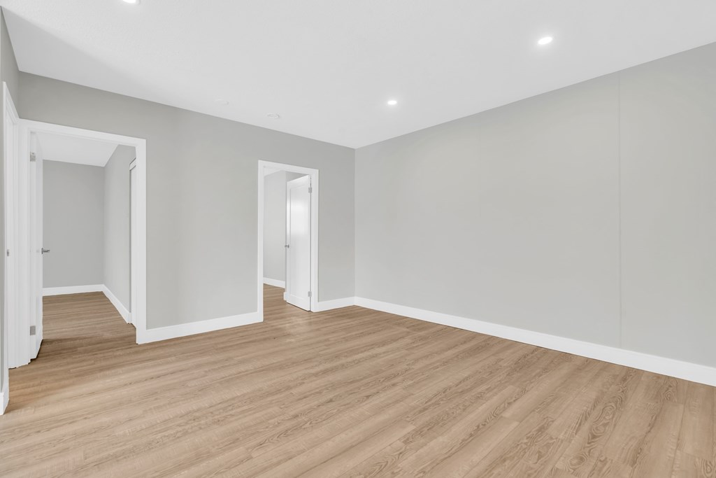 A room with wooden flooring and white walls.