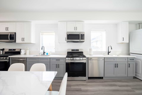 A modern kitchen with a white table and chairs.