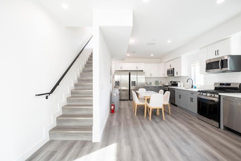 A modern kitchen with a staircase leading to the upper floor.