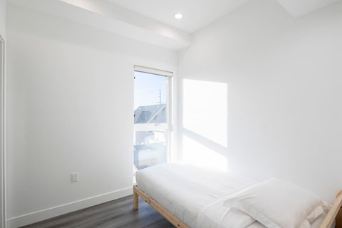 A bedroom with a bed and a window.