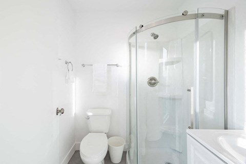 A white toilet sits next to a white sink in a bathroom.