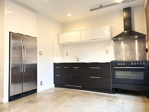 A modern kitchen with a stainless steel refrigerator and oven.