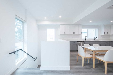 A white kitchen with a table and chairs.