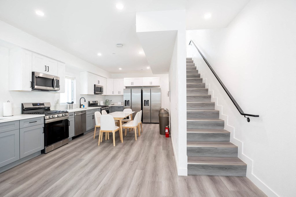 A modern kitchen with a dining table and chairs.