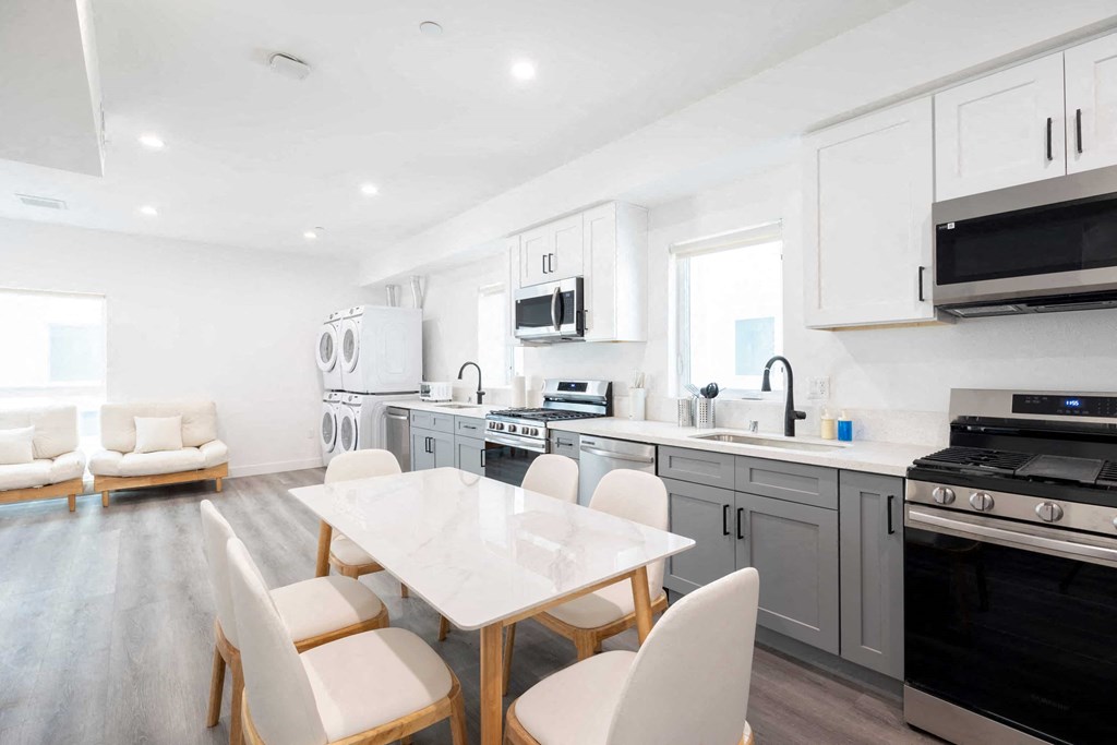 A modern kitchen with a dining table and chairs.