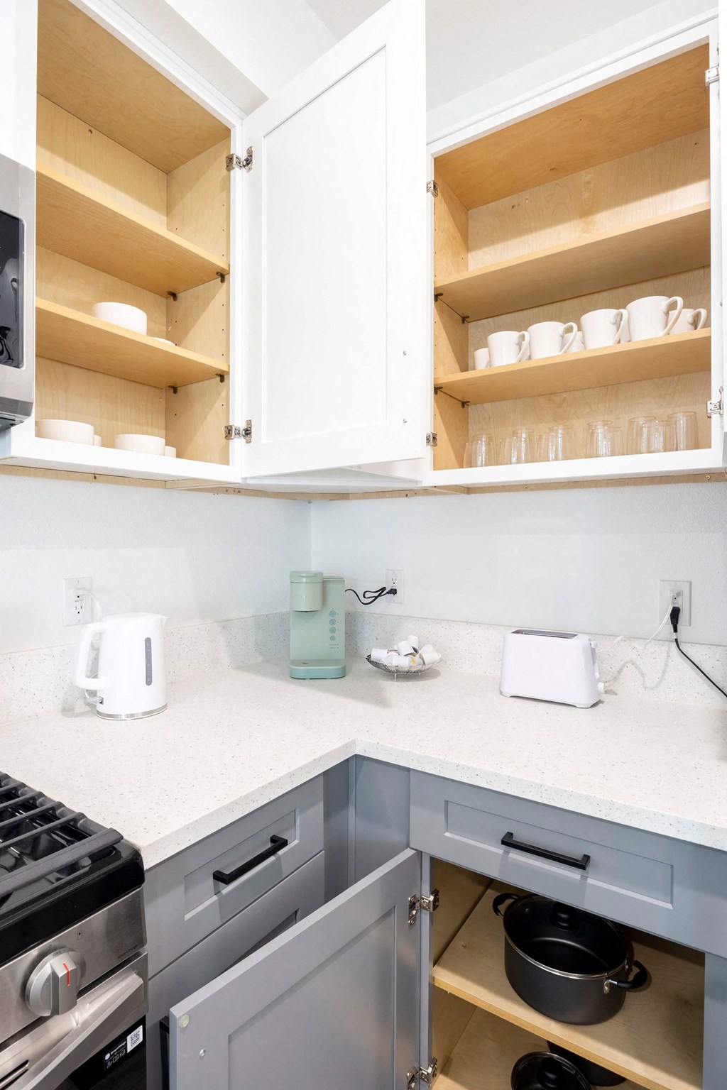 A kitchen with a toaster and a kettle on the counter.