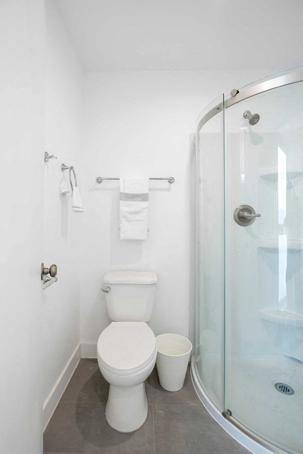 A white toilet sits next to a glass shower stall.