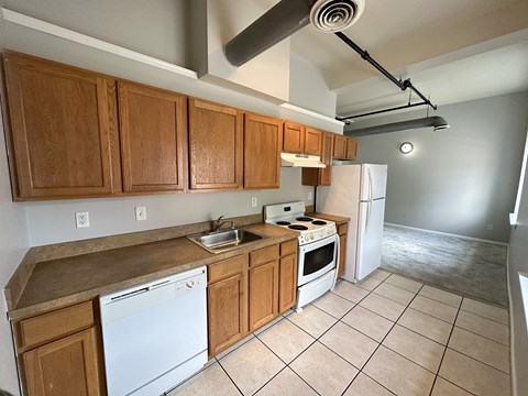A kitchen with white appliances and wooden cabinets.