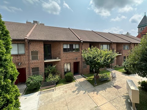 A brick apartment building with a courtyard in front.