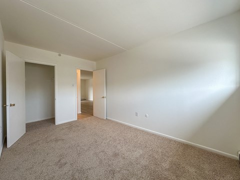 A room with a carpeted floor and a white door.