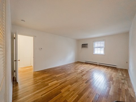 A room with wooden flooring and a window.
