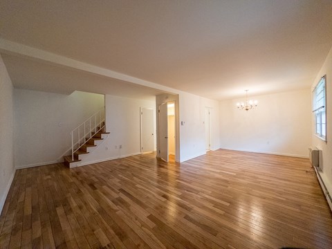 A room with wooden flooring and two doors.