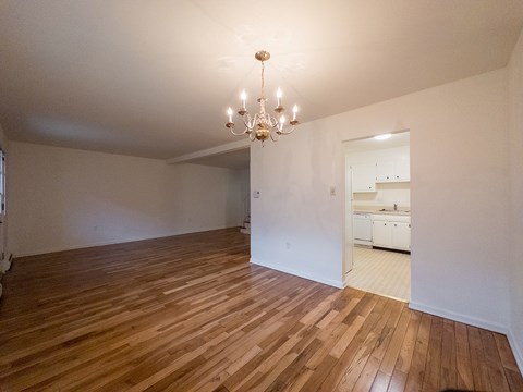 A room with wooden floors and a chandelier.