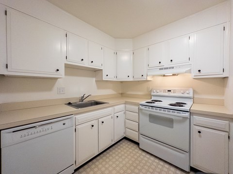 A white kitchen with a washer and dryer.