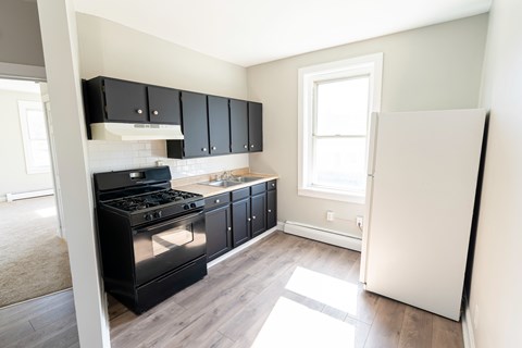 A kitchen with black cabinets and a stove top oven.
