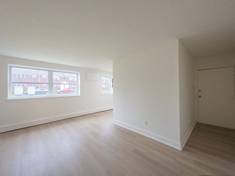 Empty room with white walls and wooden flooring.