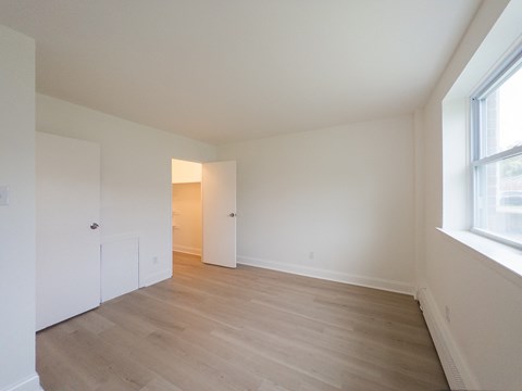 Empty room with white walls and wooden floor.