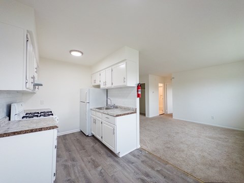 A kitchen with white cabinets and a counter top.