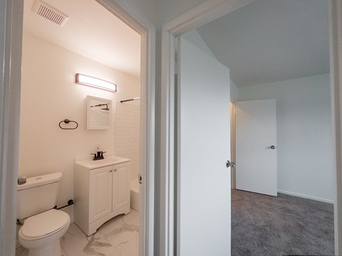 A white bathroom with a toilet, sink, and bathtub.