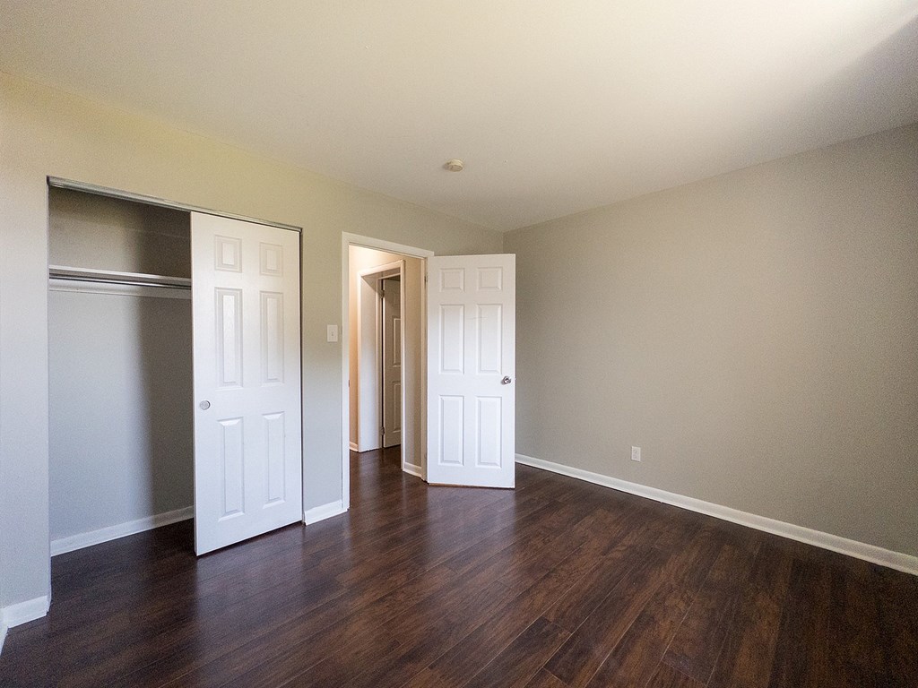 A room with two white doors and a wooden floor.