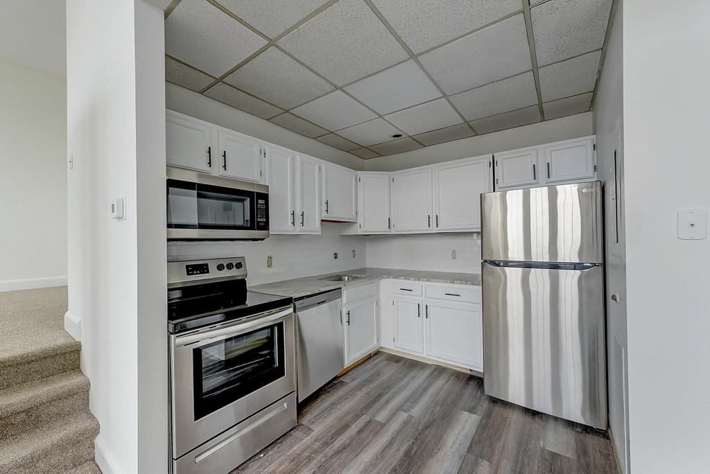 A kitchen with white cabinets and stainless steel appliances.