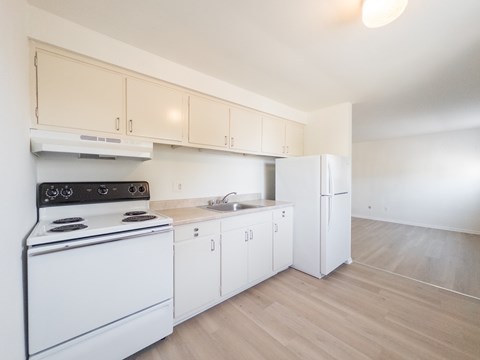 A kitchen with white appliances and cabinets.