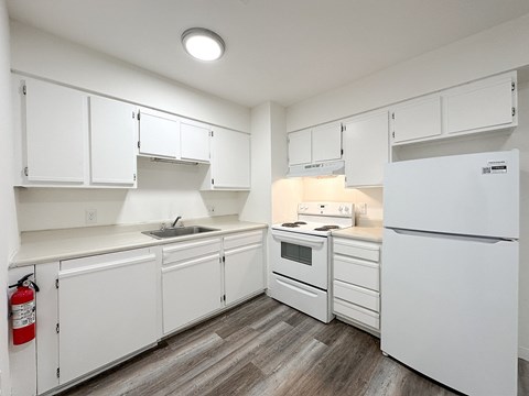 A room with a wooden floor and white walls.