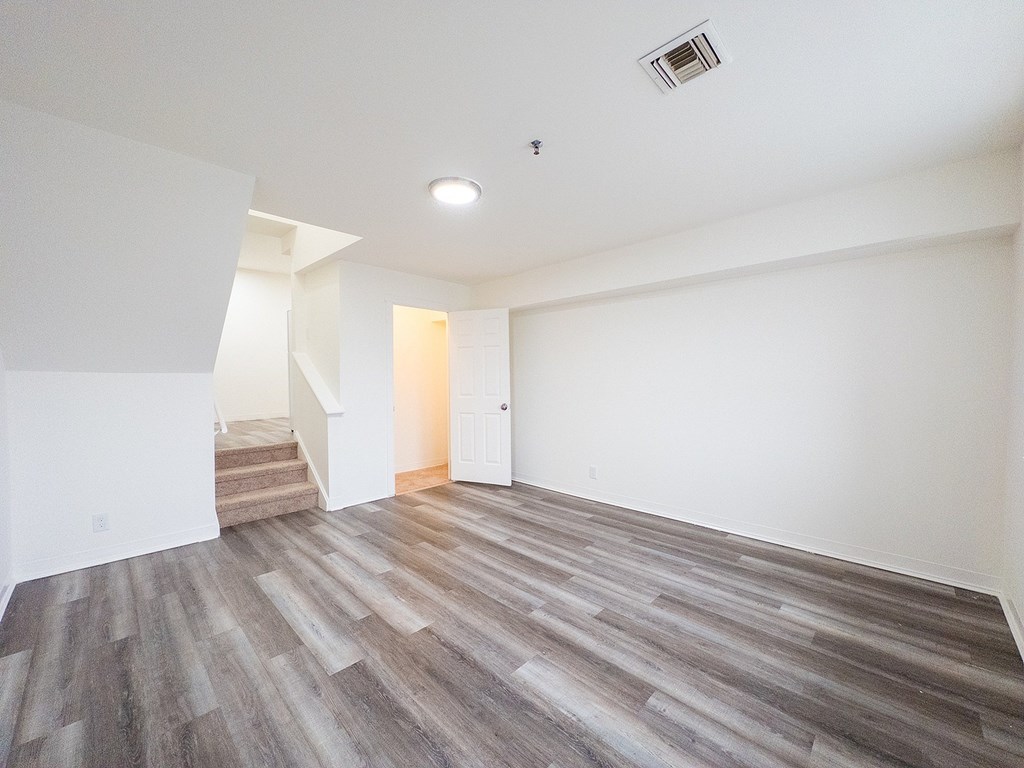 A room with a wooden floor and a window.