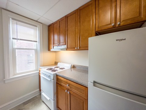 A kitchen with wooden cabinets and a white refrigerator.